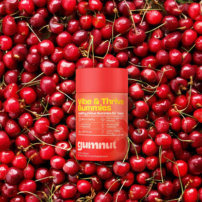 Vibe & Thrive Gummies container surrounded by red cherries